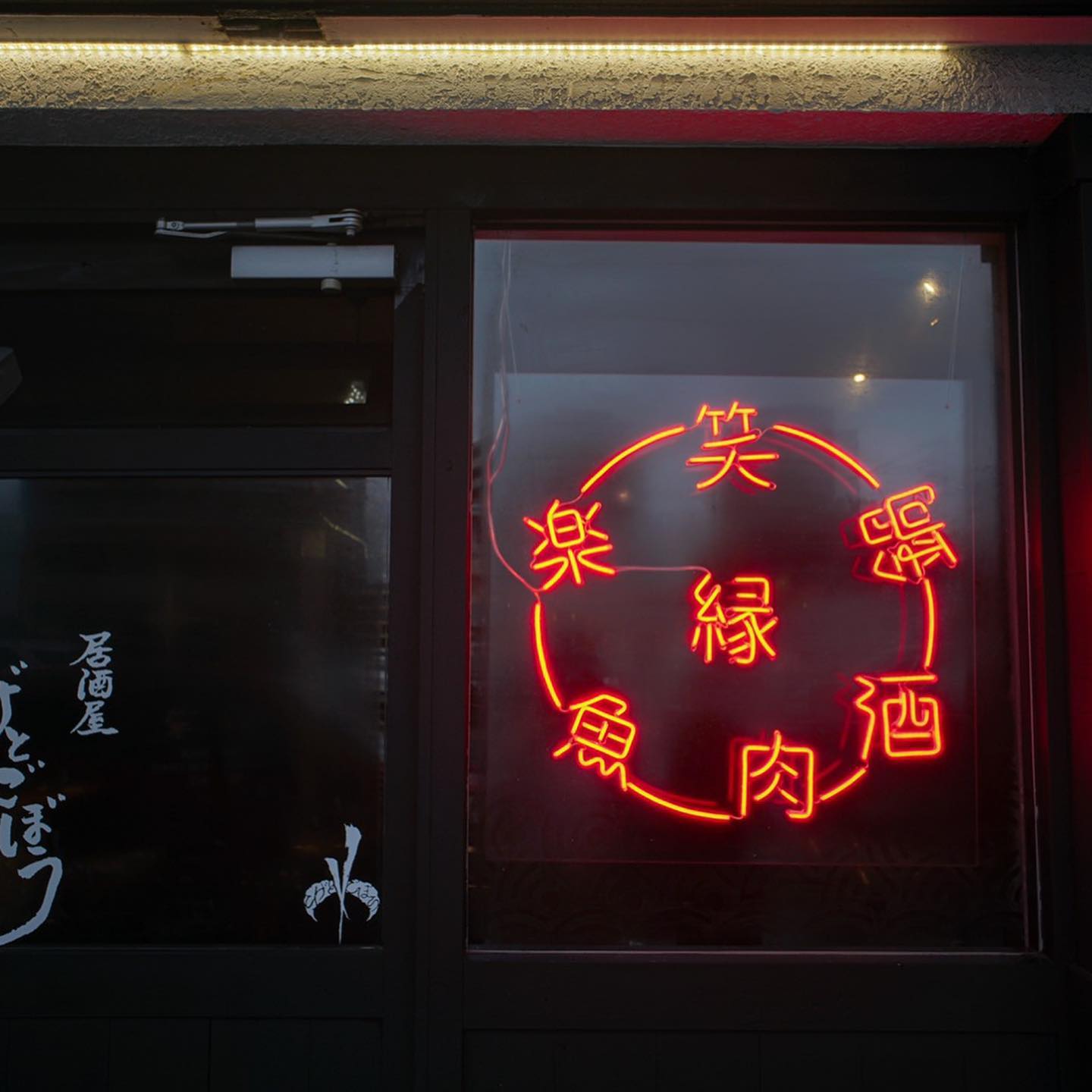 円形に文字を組んだ赤いLEDネオンサイン